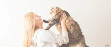 A delightful image of a woman sharing a loving moment with her fluffy cat, showcasing the joy of pet companionship.